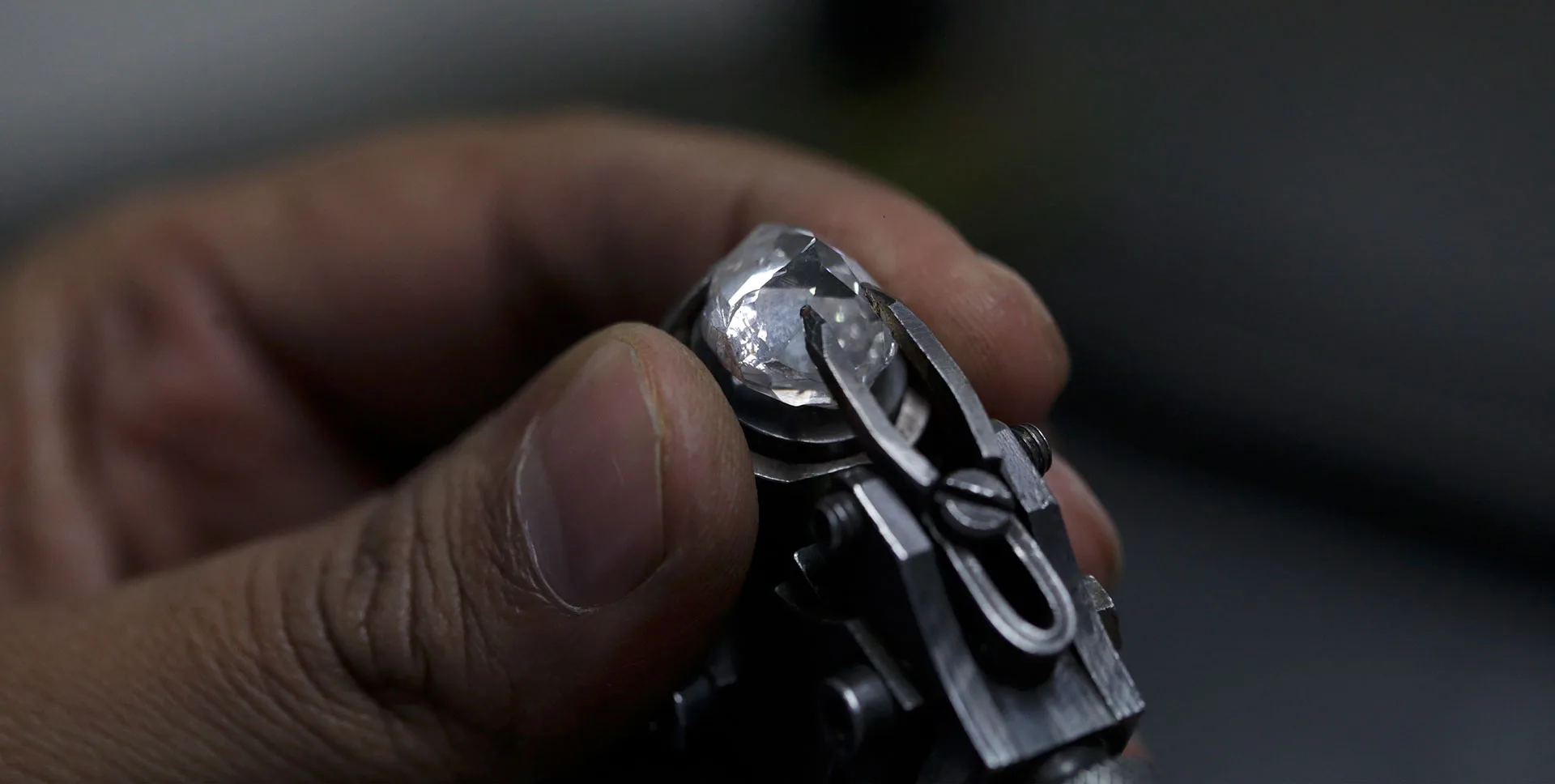 An artisan setting a diamond with precision tweezers